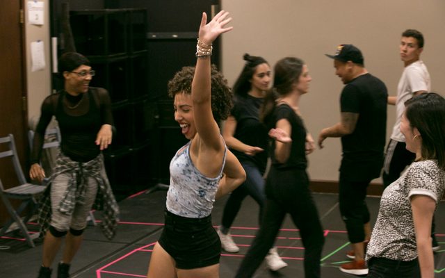 Cast members warming up in rehearsal.