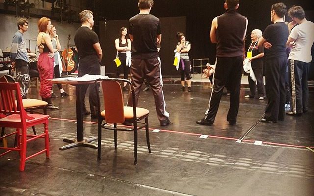 Actors in rehearsal standing in a circle