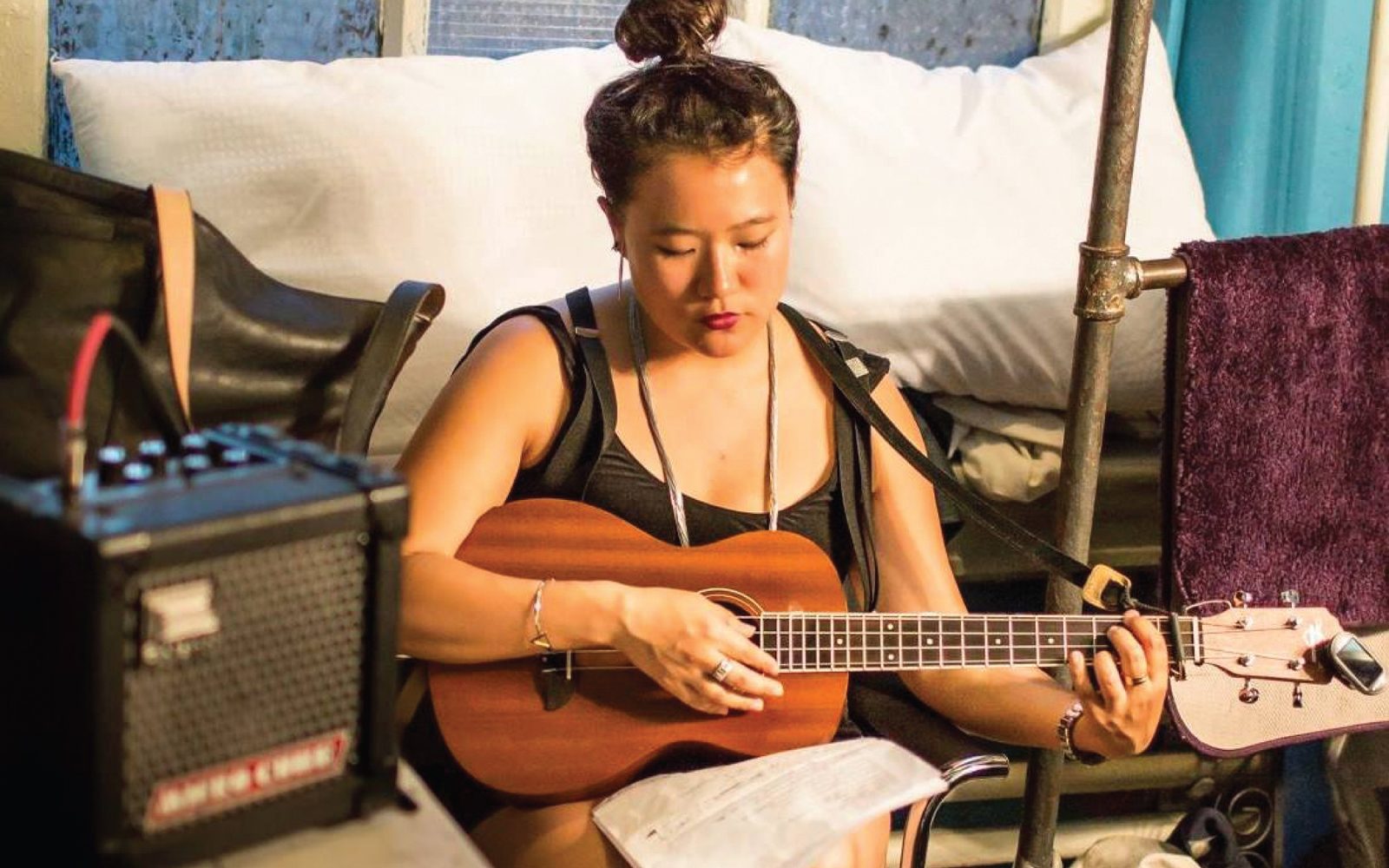 Diana Oh playing a tenor guitar