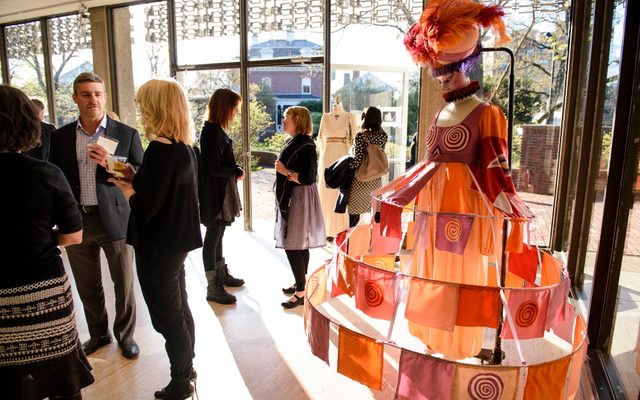 Patrons talking in the lobby next to a costume