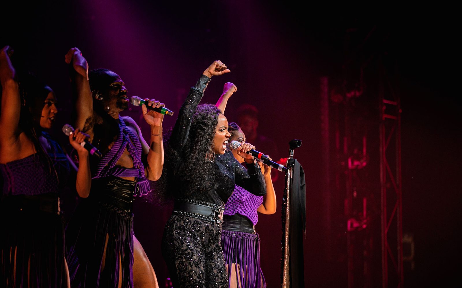 Phoenix Best, Reggie D. White, Whitney White, and Kira Sarai Helper singing with raised fists.