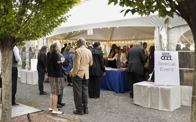 People chatting outside an events tent.