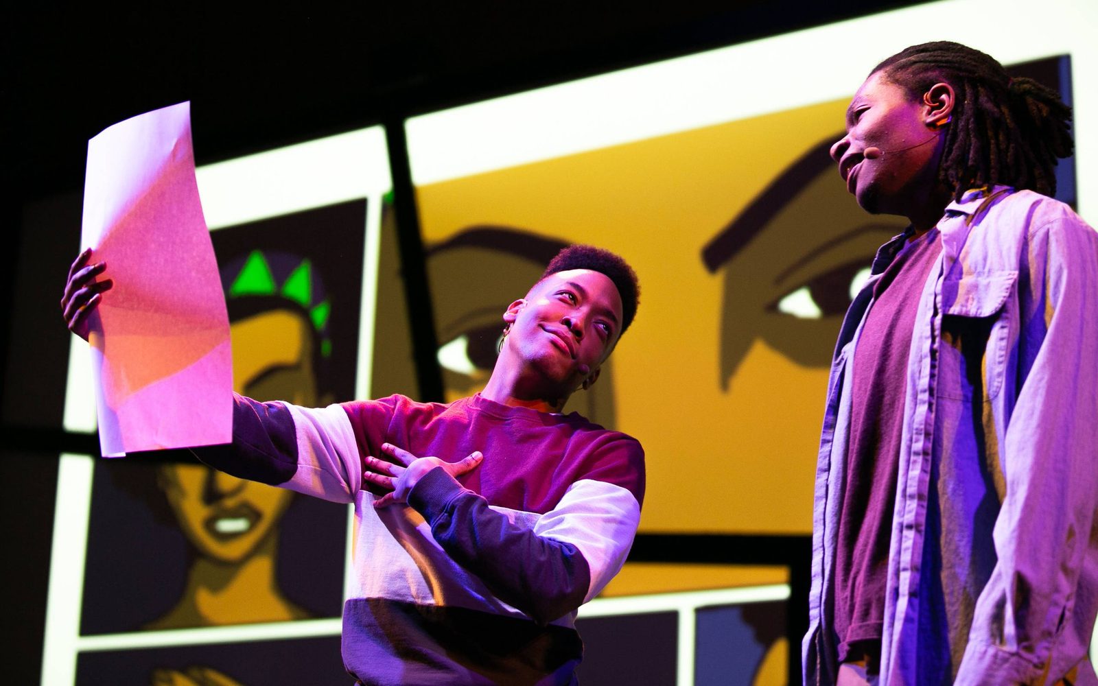 Anderson Stinson, III shows Joshua Robinson a large piece of paper in Black Super Hero Magic Mama.