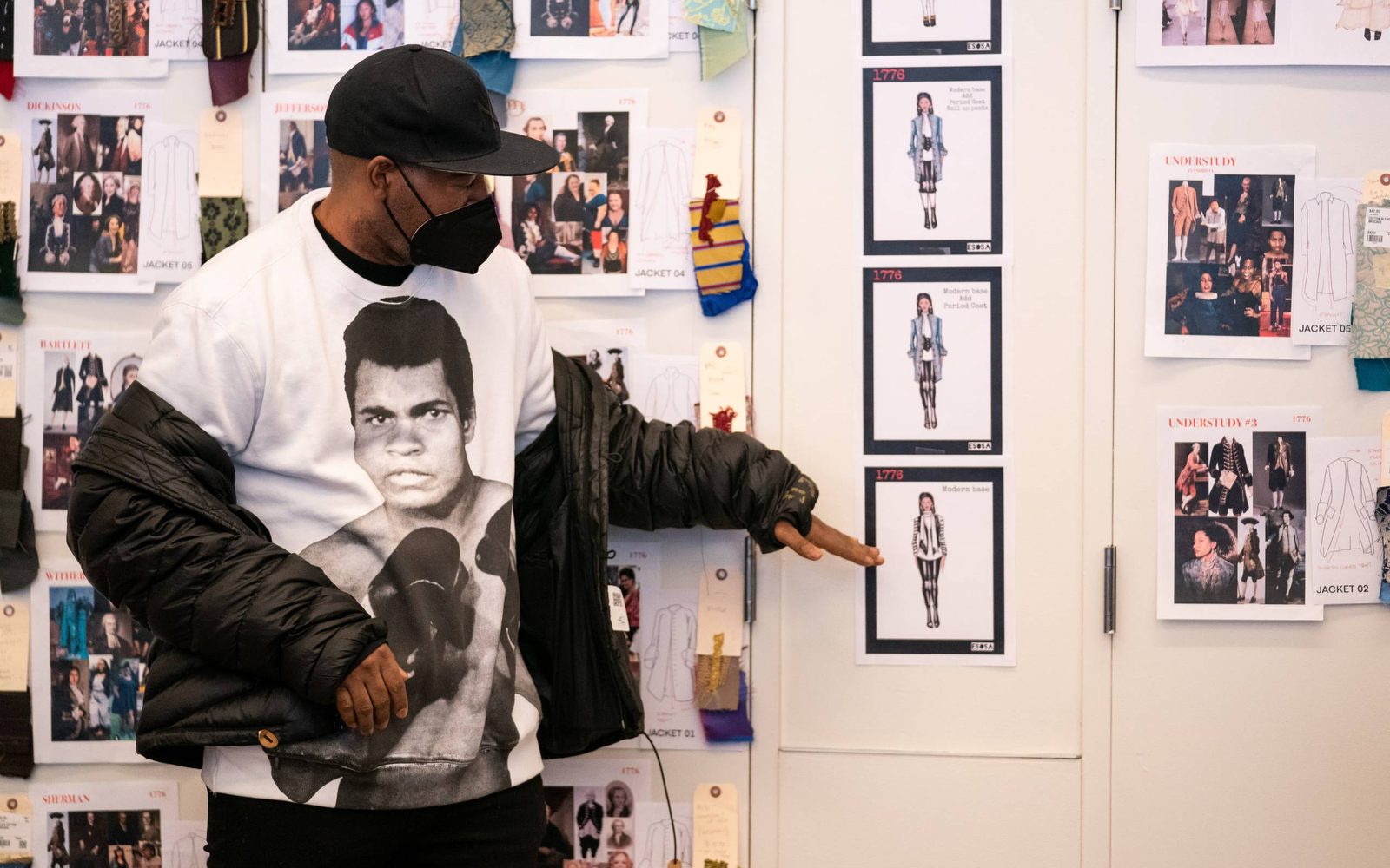 Costume Designer Emilio Sosa pointing to one of the costume designs.
