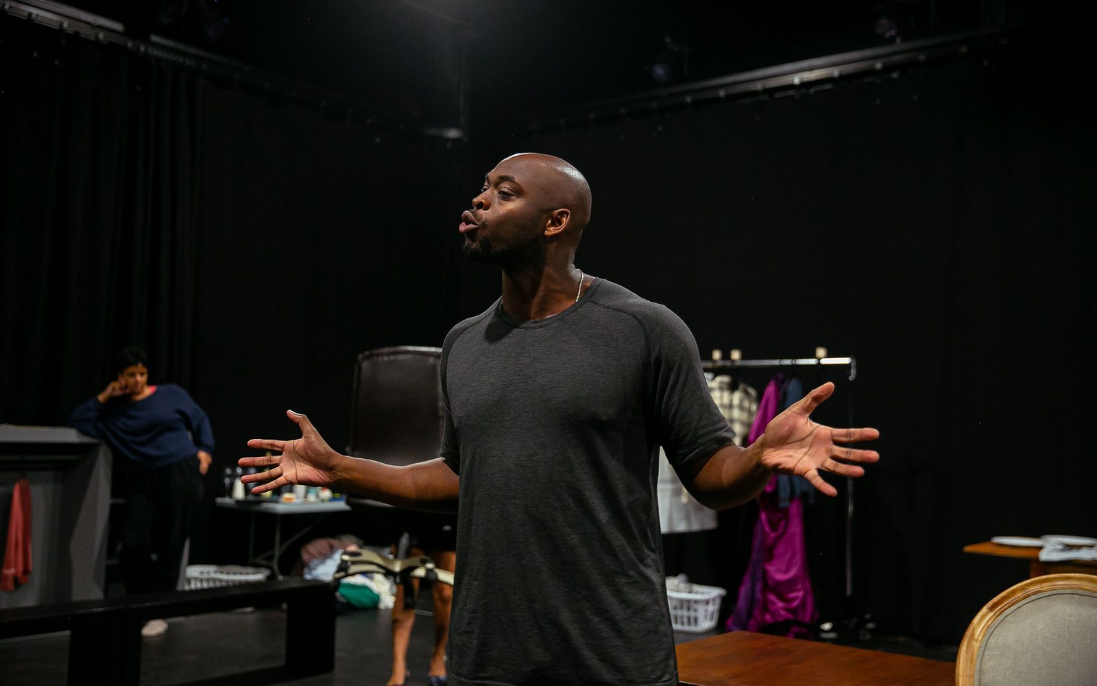 Wesley T. Jones speaking with his arms out in rehearsal.