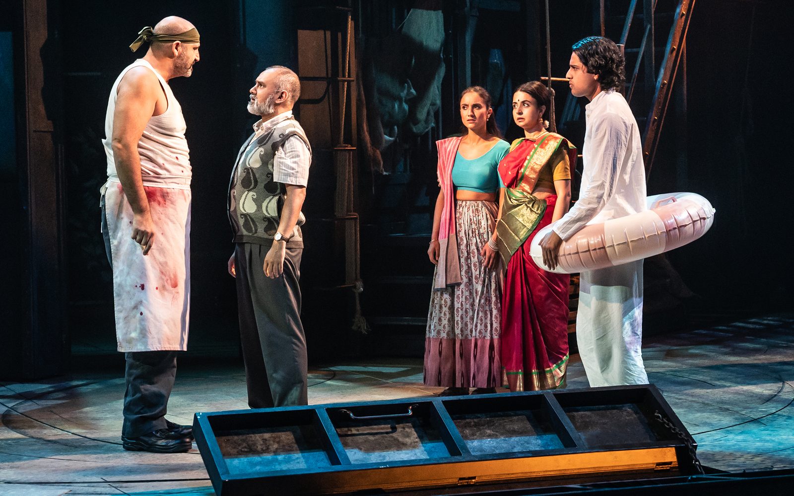 Brian Thomas Abraham is confronted by Rajesh Bose, while Sonya Venugopal, Mahira Kakkar, and Adi Dixit watch.