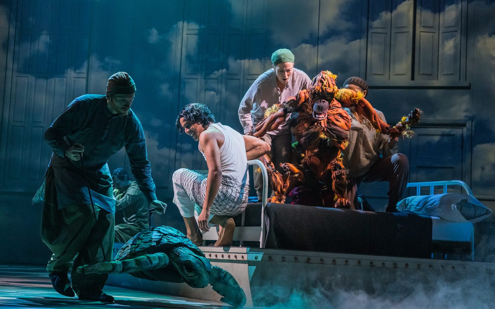 Rowan Magee swims a sea turtle puppet past Adi Dixit on the edge of a dinghy, while Celia Mei Rubin, Mahira Kakkar, and Nikki Calonge operate an orangutan puppet.