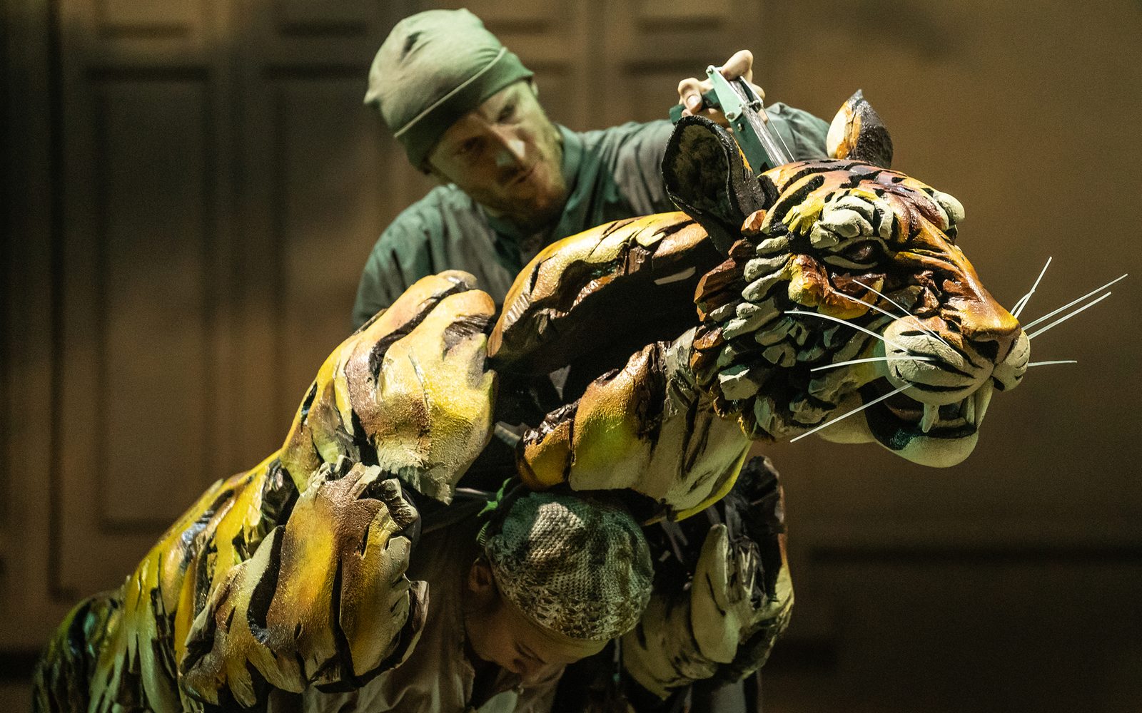 Rowan Magee manipulates the head of the tiger puppet while Celia Mei Rubin holds up its torso.
