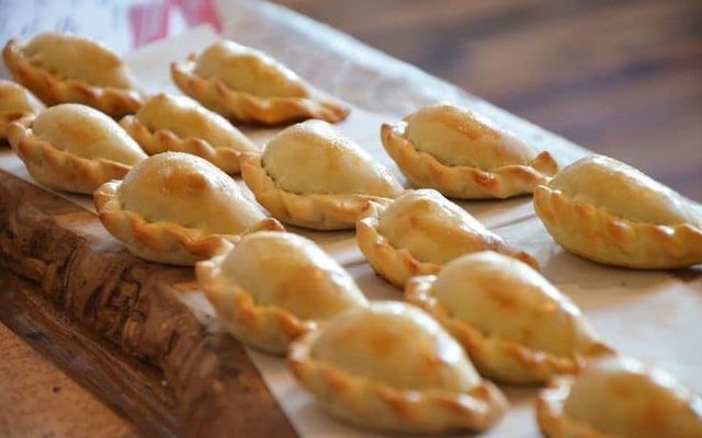 Plump empanadas on a wood board