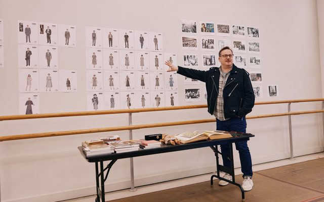 Evita Costume Designer Alejo Vietti gestures to a wall of costume design images.