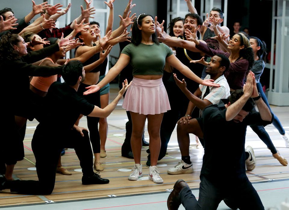 Shereen Pimentel stands proudly surrounded by the ensemble, as Omar Lopez-Cepero kneels in front of her with his hands clasped in prayer.