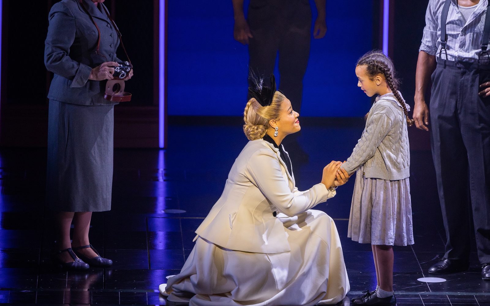 Shereen Pimentel (Eva) kneels in front of Sky Vaux Fuller (Child), holding her hand..