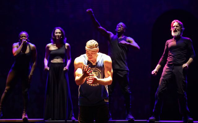 Mister Fitzgerald in a Golden State Warriors jersey is lit centerstage as Jennifer Mogbock, Kelley Curran, Jason Bowen, and Michael Laurence look on excitedly behind him.