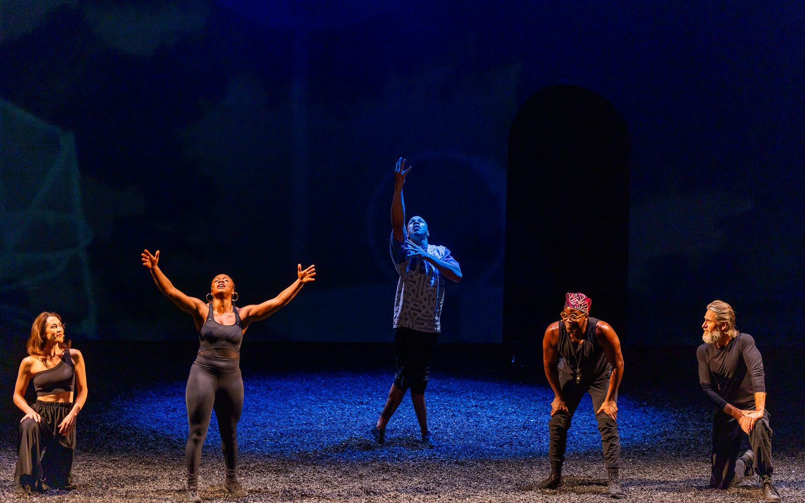 Jennifer Mogbock raises her hands while Kelley Curran, Jason Bowen, and Michael Laurence watch her, and while Mister Fitzgerald bathed in blue light dances with a raised hand behind them.
