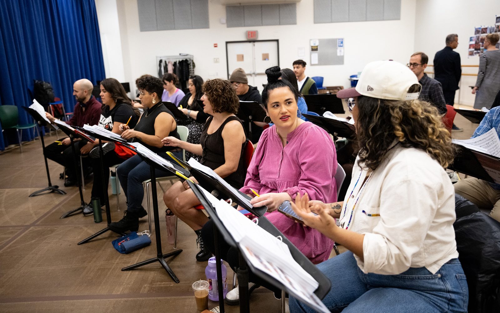 Lucy Godínez and the company sit at music stands.