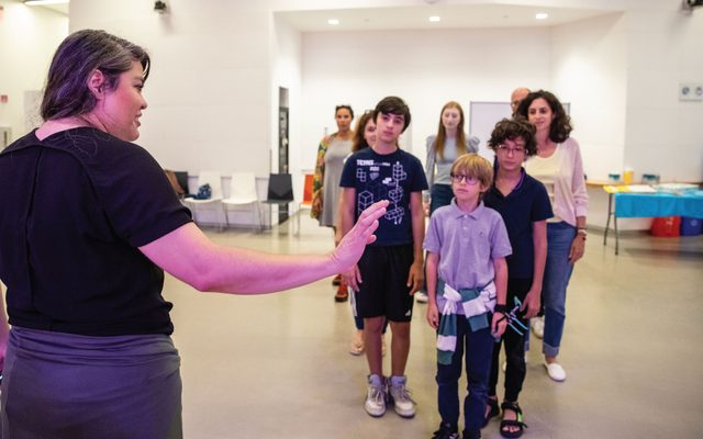 Brisa Areli Muñoz directs children standing in a wedge during a workshop.