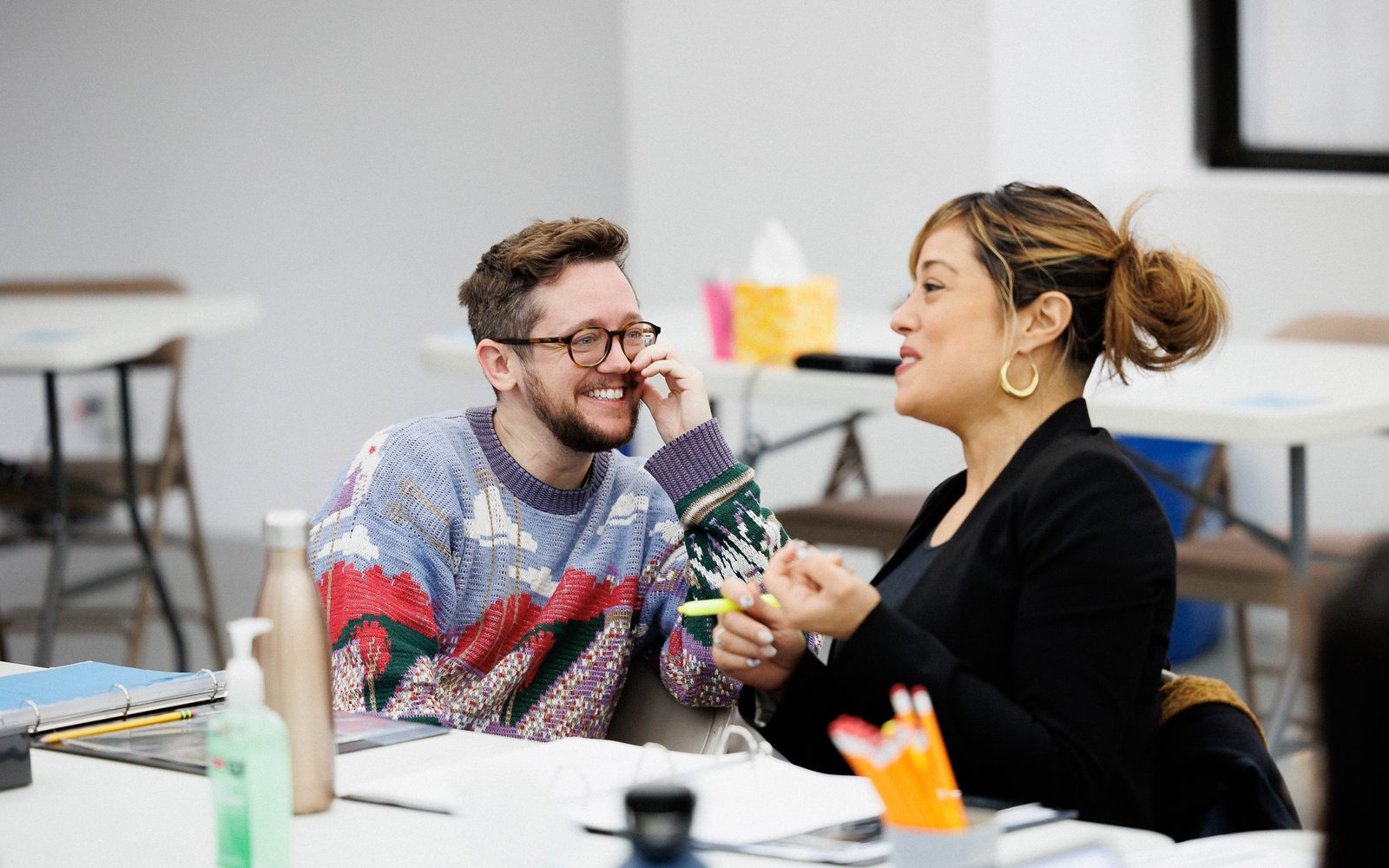 Petey Gibson and Elena Hurst chat while sitting at a table.