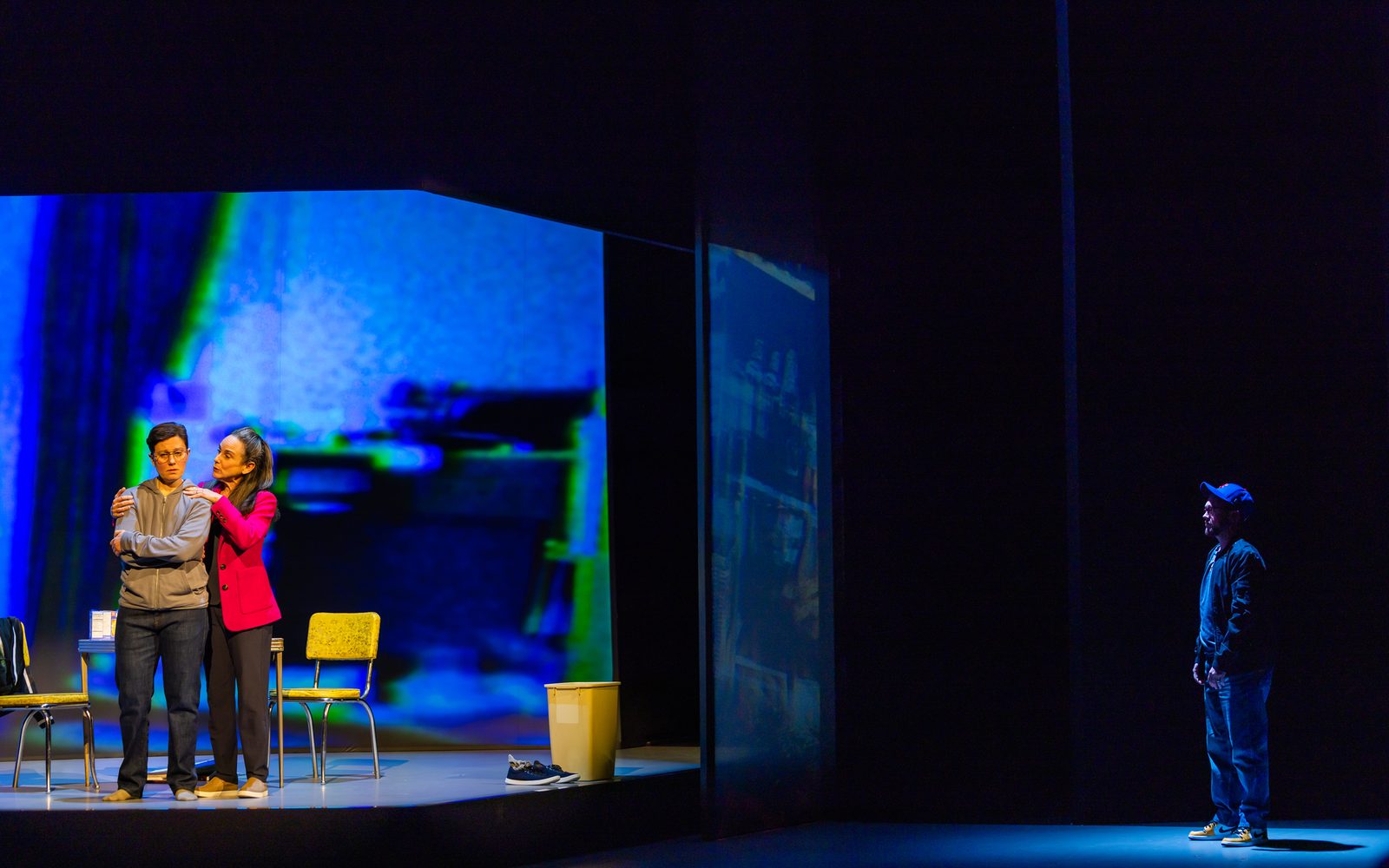 Susan Rome holds Stacey Raymond's shoulders while Petey Gibson watches from the darkness.