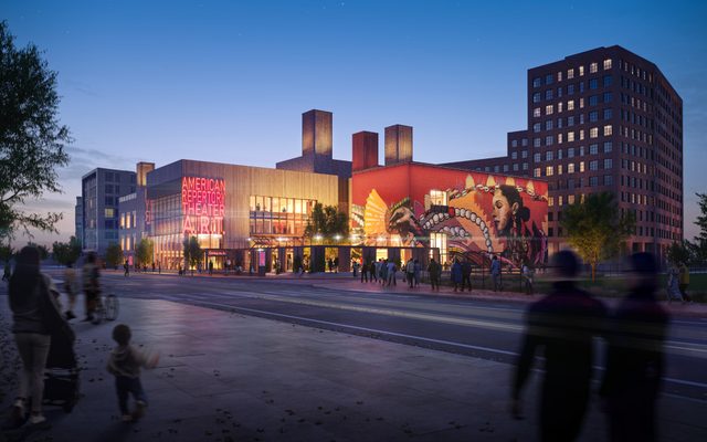 The exterior at night, with a large mural on the wall to the right.