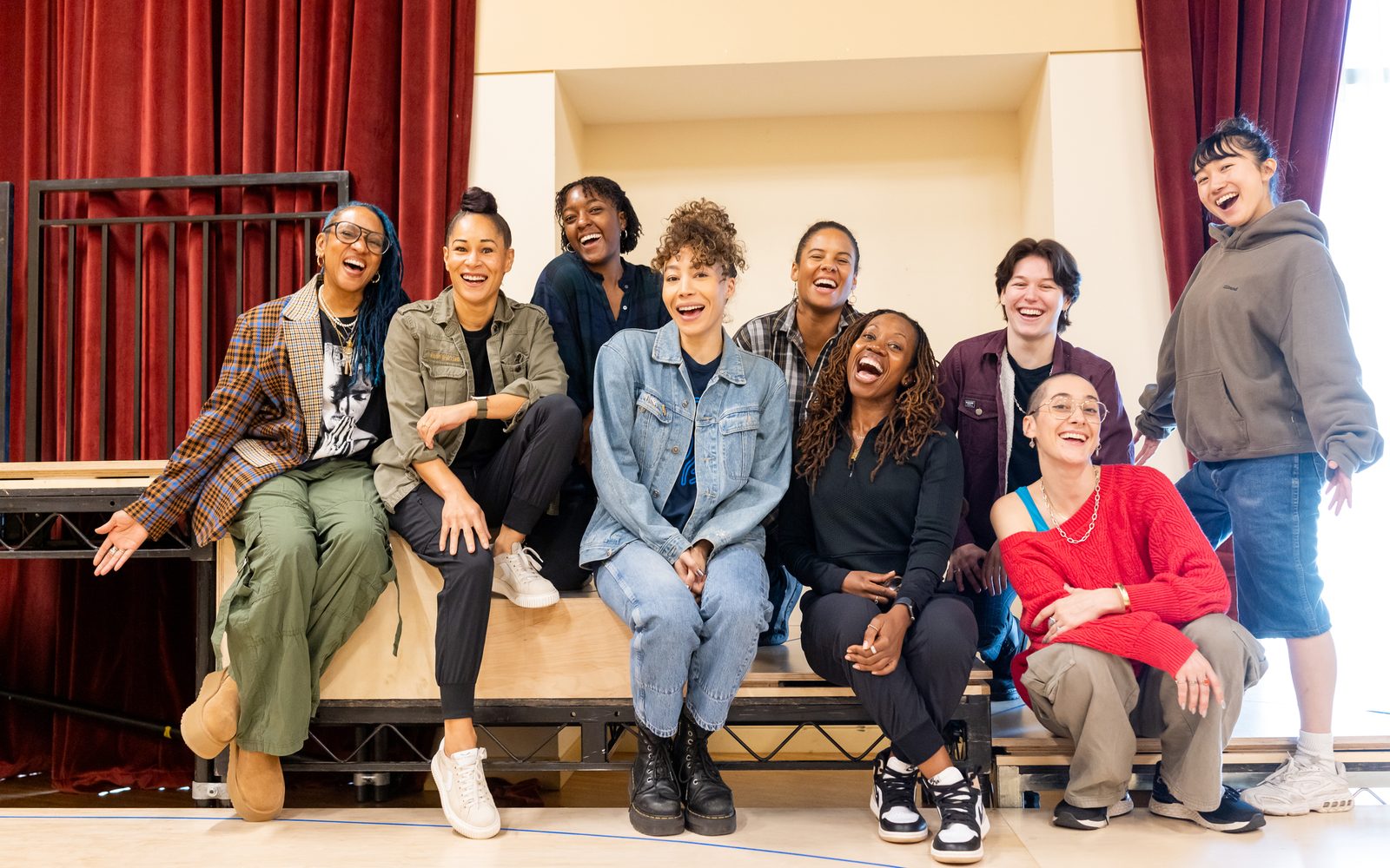 A group shot of the cast and the director arranged in two rows.
