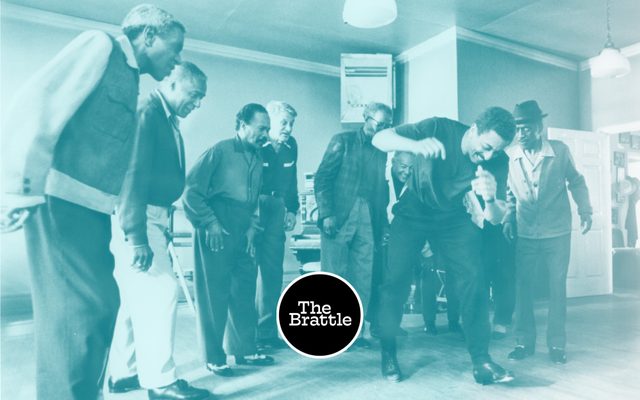 Gregory Hines tap dancing in a group of older men.