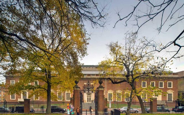 A view of the red brick facade of the Harvard Art Museums from inside Harvard Yard.