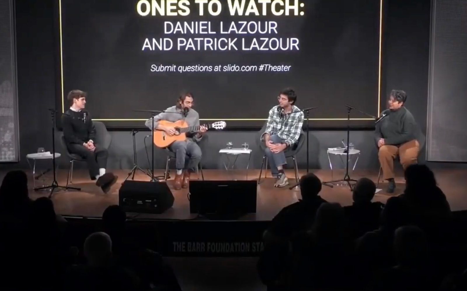 Taylor Trensch, Daniel Lazour, Patrick Lazour, and Cristela Guerra sitting on a stage.