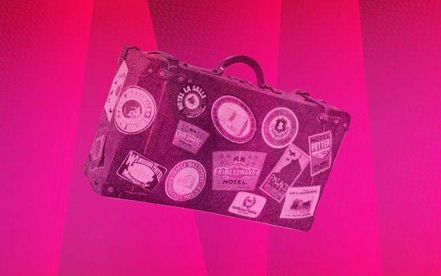 A stylized photograph of a sticker-covered portmanteau over a background of varying shades of pink.