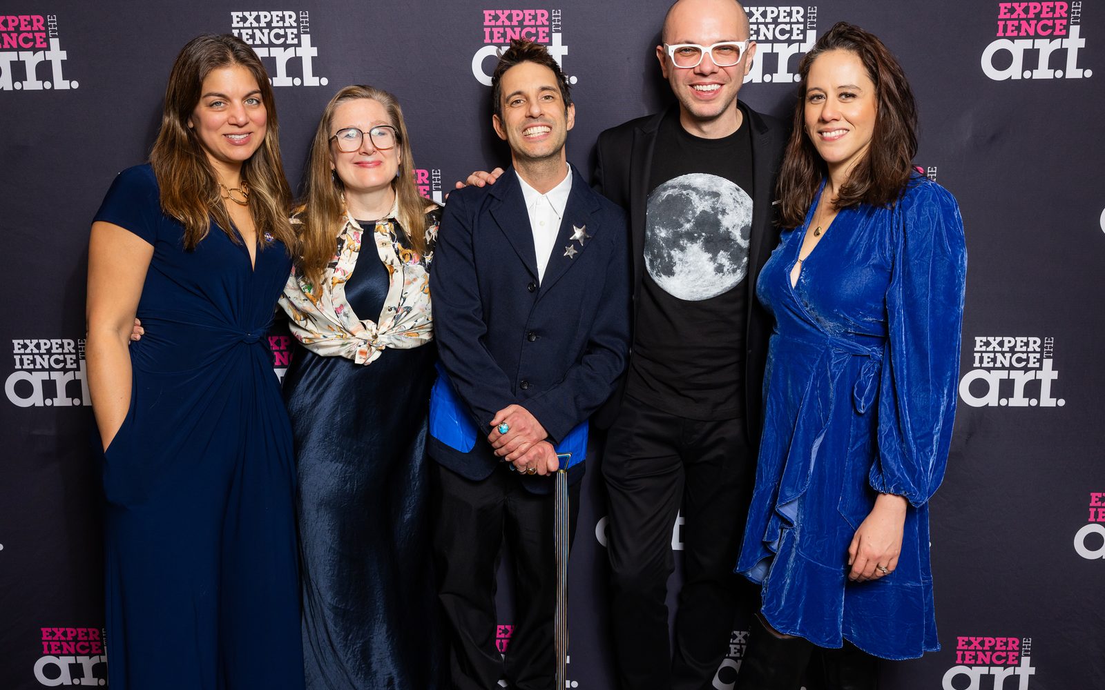 Nadia DiGiallonardo, Sarah Ruhl, Chad King, Ian Axel, and Taibi Magar, all dressed up, stand together smiling in front of a step-and-repeat.
